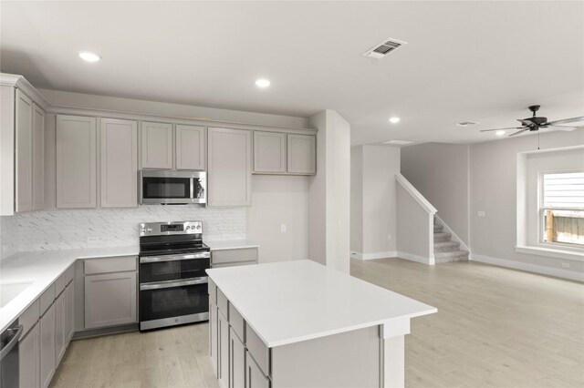 9708 Petrichor Blvd, Manor, TX 78653 - kitchen featuring stainless steel appliances, gray cabinets, tasteful backsplash, a center island, and recessed lighting