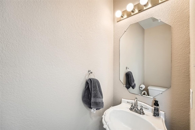 2813 Single Trace Ct, Austin, TX 78728 - bathroom featuring toilet, a textured wall, and a sink