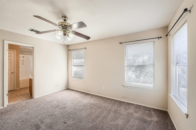 2813 Single Trace Ct, Austin, TX 78728 - unfurnished bedroom with visible vents, ceiling fan, a textured ceiling, connected bathroom, and carpet flooring