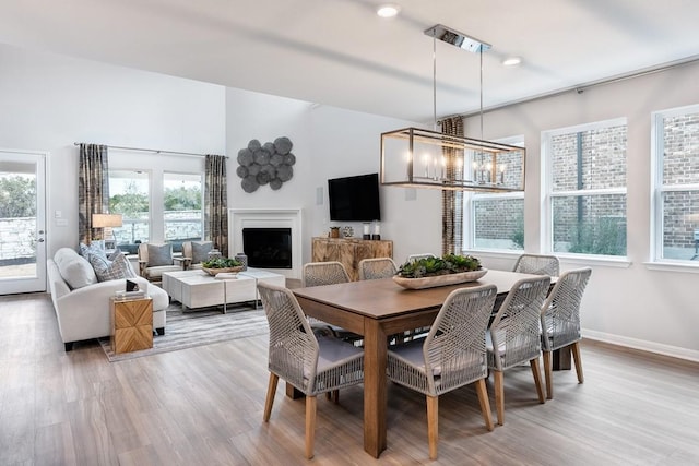 9709 Boathouse Dr, Austin, TX 78744 - dining space featuring light wood-style floors, a fireplace, and baseboards
