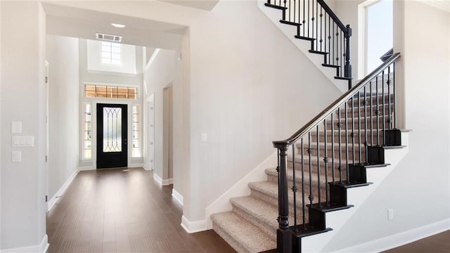 9709 Boathouse Dr, Austin, TX 78744 - entrance foyer featuring stairs, baseboards, wood finished floors, and a towering ceiling