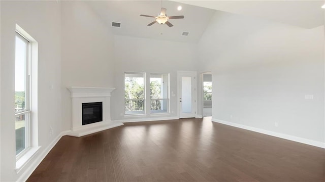 9709 Boathouse Dr, Austin, TX 78744 - unfurnished living room with high vaulted ceiling, ceiling fan, a glass covered fireplace, baseboards, and dark wood-style flooring