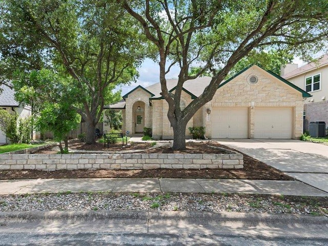 906 Woodhollow Ln, Cedar Park, TX 78613 - view of front of home with a garage, central AC, stone siding, and concrete driveway