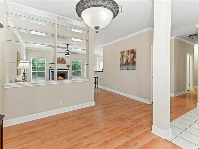 906 Woodhollow Ln, Cedar Park, TX 78613 - unfurnished living room featuring crown molding, a ceiling fan, a warm lit fireplace, and wood finished floors