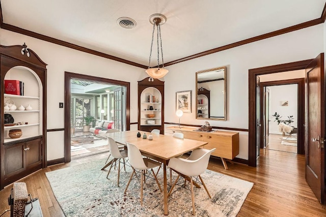 809 Edgecliff Ter, Austin, TX 78704 - dining space featuring light wood-style flooring, ornamental molding, baseboards, and built in shelves