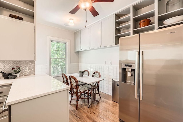 809 Edgecliff Ter, Austin, TX 78704 - kitchen with stainless steel refrigerator with ice dispenser, light wood finished floors, ceiling fan, a wainscoted wall, and a peninsula
