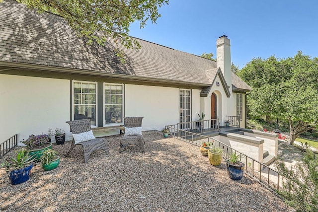 809 Edgecliff Ter, Austin, TX 78704 - back of house with stucco siding, roof with shingles, a chimney, and a patio area