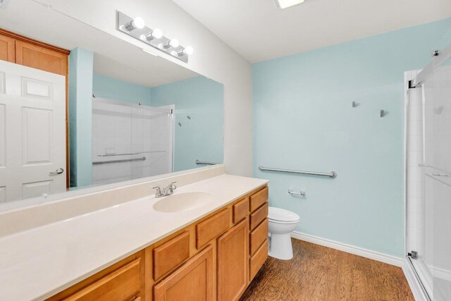 128 2nd Ave, Taylor, TX 76574 - full bath featuring a shower with shower door, vanity, and wood finished floors