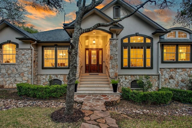 201 Mcconnell Dr, West Lake Hills, TX 78746 - exterior entry at dusk featuring stone siding and stucco siding