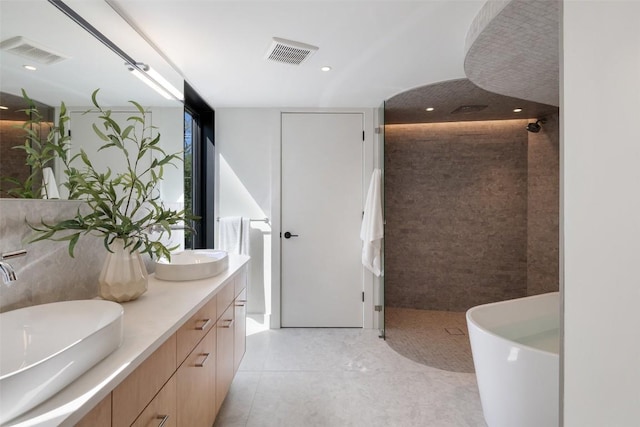 2218 Haskell St, Austin, TX 78702 - bathroom featuring a tile shower, double vanity, a freestanding tub, tile patterned floors, and recessed lighting