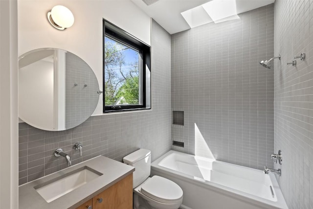 2218 Haskell St, Austin, TX 78702 - bathroom with tile walls, bathtub / shower combination, vanity, toilet, and tasteful backsplash