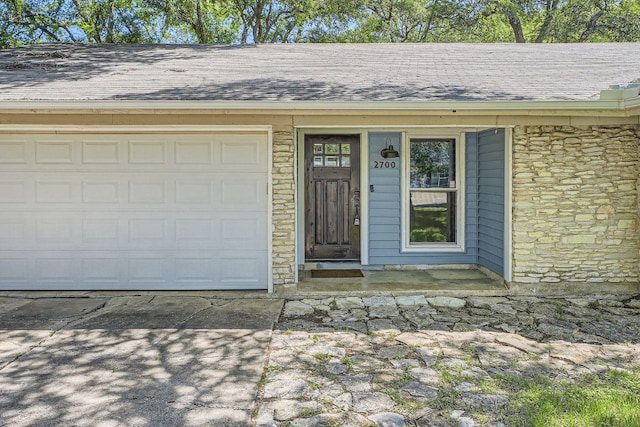 2700 Coatbridge Dr, Austin, TX 78745 - doorway to property with a shingled roof, driveway, stone siding, and an attached garage