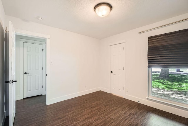 2700 Coatbridge Dr, Austin, TX 78745 - unfurnished room featuring baseboards, a textured ceiling, and dark wood finished floors