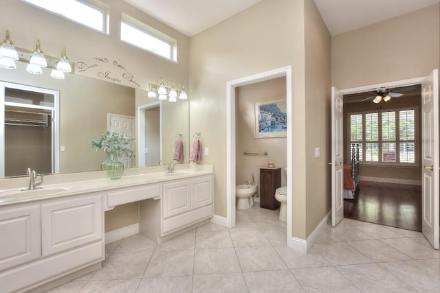 204 Whippoorwill Cv, Georgetown, TX 78633 - full bathroom featuring a bidet, double vanity, tile patterned flooring, baseboards, and a towering ceiling