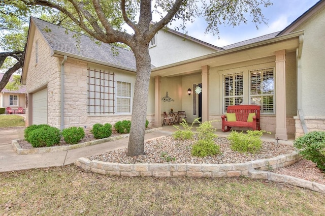 204 Whippoorwill Cv, Georgetown, TX 78633 - view of front facade with stone siding, an attached garage, stucco siding, and roof with shingles