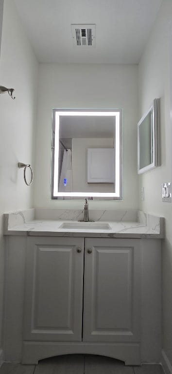 full bathroom featuring visible vents and vanity