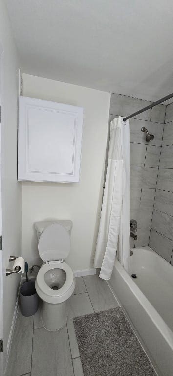 bathroom featuring baseboards and shower / bathtub combination with curtain