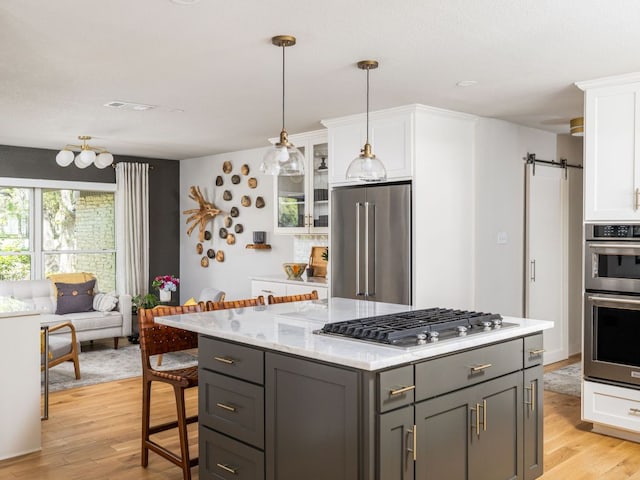 6022 Tonkowa Trl, Georgetown, TX 78628 - kitchen with stainless steel appliances, white cabinets, light wood-style floors, and gray cabinetry