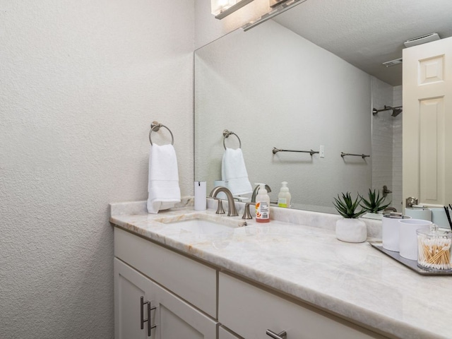 6022 Tonkowa Trl, Georgetown, TX 78628 - bathroom featuring vanity, a shower, a textured wall, and a textured ceiling