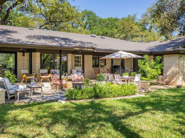 6022 Tonkowa Trl, Georgetown, TX 78628 - rear view of house featuring a shingled roof, a yard, and brick siding