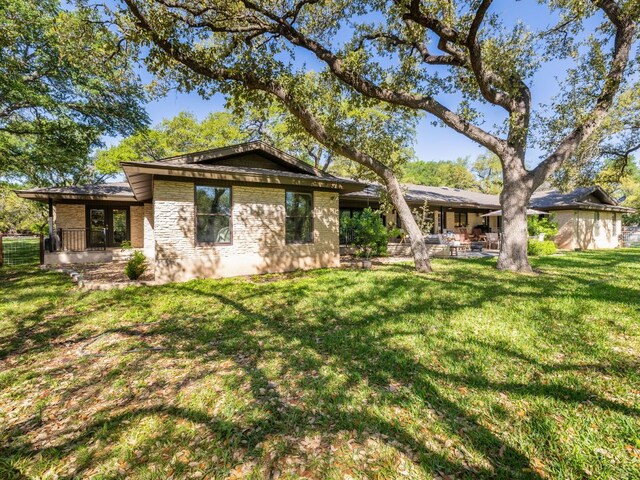 6022 Tonkowa Trl, Georgetown, TX 78628 - back of house featuring brick siding, a lawn, and a patio