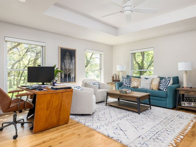 6022 Tonkowa Trl, Georgetown, TX 78628 - living room featuring light wood-type flooring, a raised ceiling, ceiling fan, and an office area
