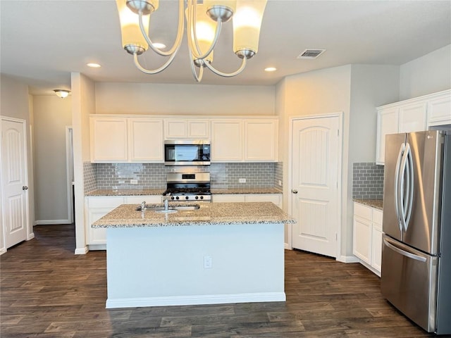 3409 Brywood Dr, Pflugerville, TX 78660 - kitchen with stainless steel appliances, light stone countertops, decorative backsplash, white cabinetry, and a center island with sink