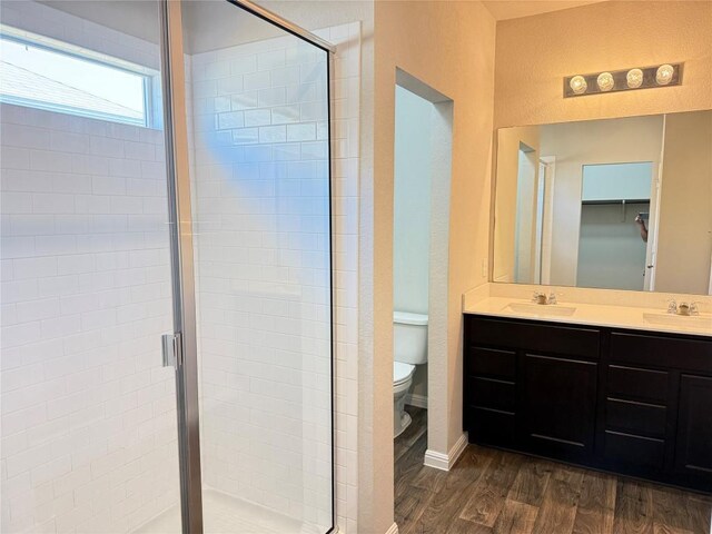 3409 Brywood Dr, Pflugerville, TX 78660 - full bath featuring wood finished floors, toilet, a shower stall, and double vanity