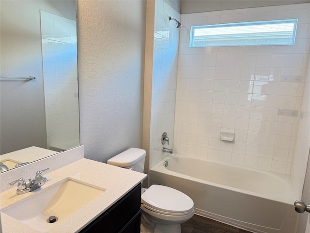 3409 Brywood Dr, Pflugerville, TX 78660 - full bathroom with toilet, vanity, shower / washtub combination, a textured wall, and wood finished floors