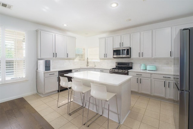 11700 Misty White Dr, Austin, TX 78717 - kitchen featuring stainless steel appliances, backsplash, a kitchen breakfast bar, a kitchen island, and recessed lighting