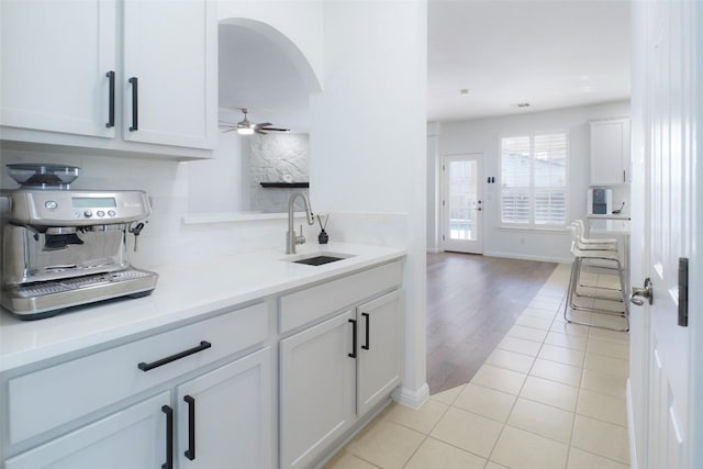 11700 Misty White Dr, Austin, TX 78717 - kitchen featuring tasteful backsplash, white cabinets, ceiling fan, arched walkways, and light tile patterned floors
