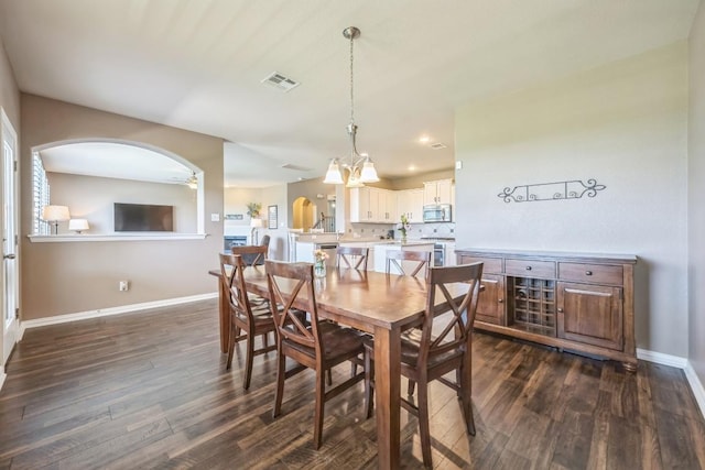 3505 Grail Hollows Rd, Pflugerville, TX 78660 - dining room with dark wood-type flooring, baseboards, arched walkways, ceiling fan, and a chandelier