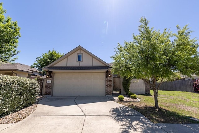 702 Silo St, San Marcos, TX 78666 - tudor home with concrete driveway, brick siding, a garage, and a gate