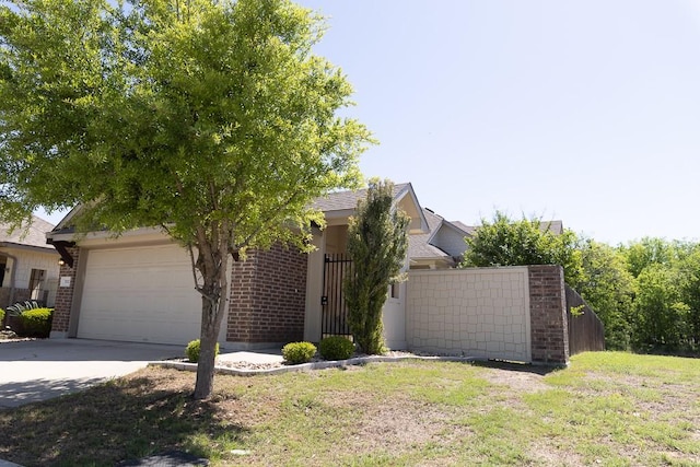 702 Silo St, San Marcos, TX 78666 - obstructed view of property with a garage, brick siding, and concrete driveway