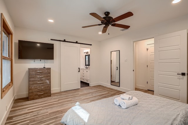 bedroom with baseboards, recessed lighting, a barn door, light wood-style floors, and ceiling fan