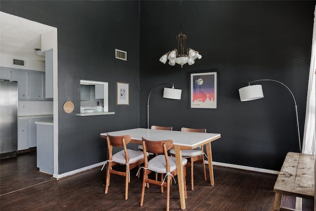 19 Deerfield Dr Unit 2, Wimberley, TX 78676 - dining space featuring a chandelier, dark wood-style floors, and a towering ceiling