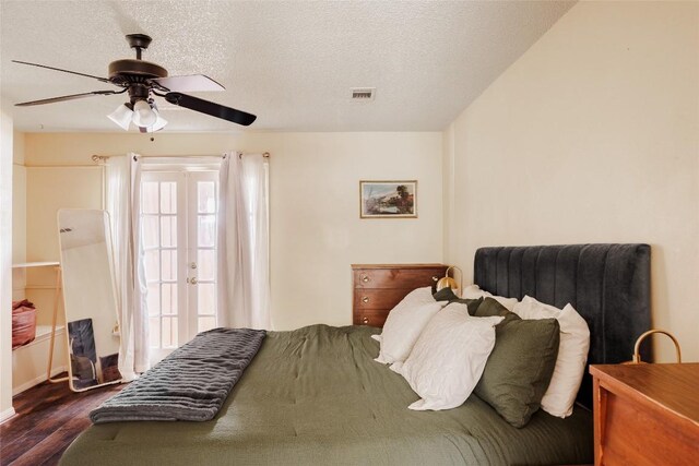 19 Deerfield Dr Unit 2, Wimberley, TX 78676 - bedroom featuring dark wood-type flooring, a ceiling fan, a textured ceiling, and french doors