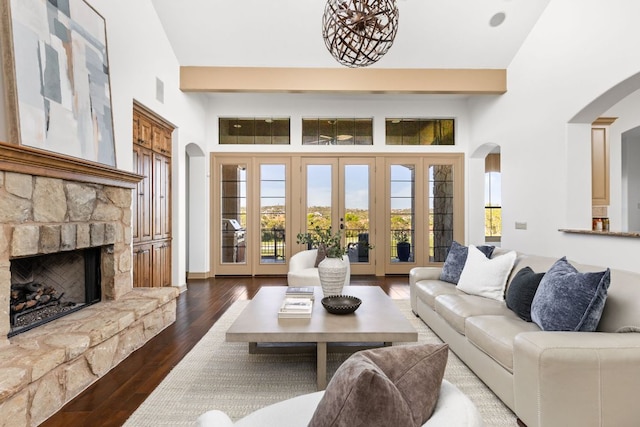 219 Jack Nicklaus Dr, Austin, TX 78738 - living room featuring arched walkways, a stone fireplace, and wood finished floors