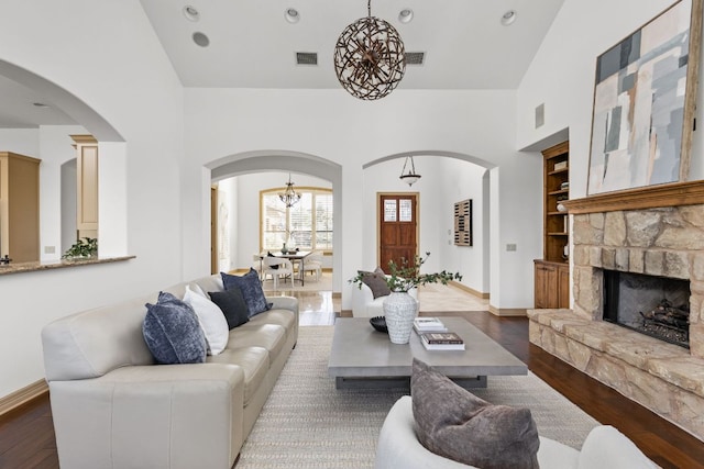 219 Jack Nicklaus Dr, Austin, TX 78738 - living area with arched walkways, wood finished floors, built in features, a high ceiling, and a stone fireplace