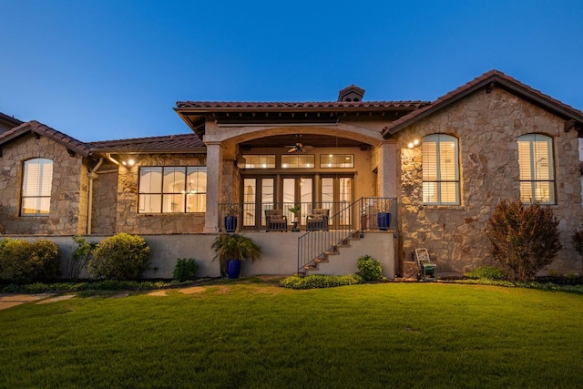 219 Jack Nicklaus Dr, Austin, TX 78738 - view of front of property with stone siding, a front yard, a ceiling fan, a tile roof, and stucco siding