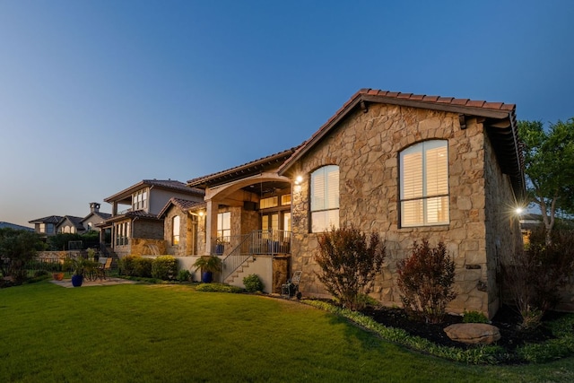 219 Jack Nicklaus Dr, Austin, TX 78738 - mediterranean / spanish-style home with stone siding and a front lawn