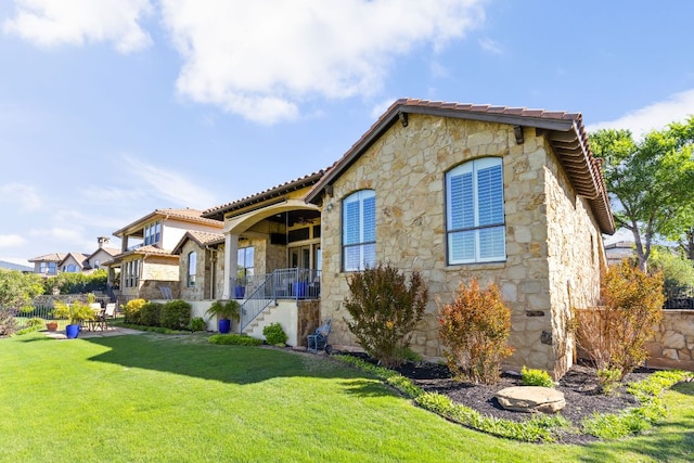 219 Jack Nicklaus Dr, Austin, TX 78738 - view of front of house with stone siding, a tile roof, stairs, and a patio area