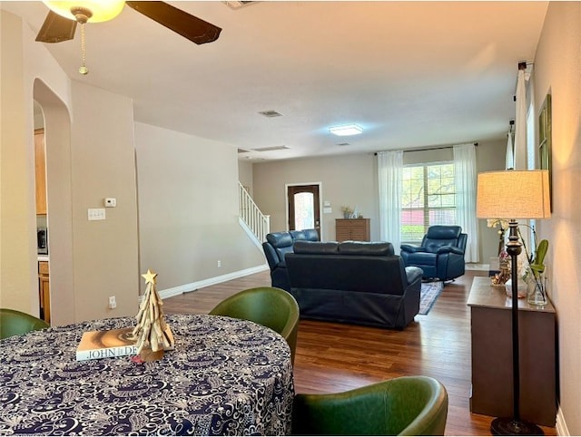 2201 Ezra Ct, Cedar Park, TX 78613 - dining room with arched walkways, wood finished floors, a ceiling fan, and baseboards