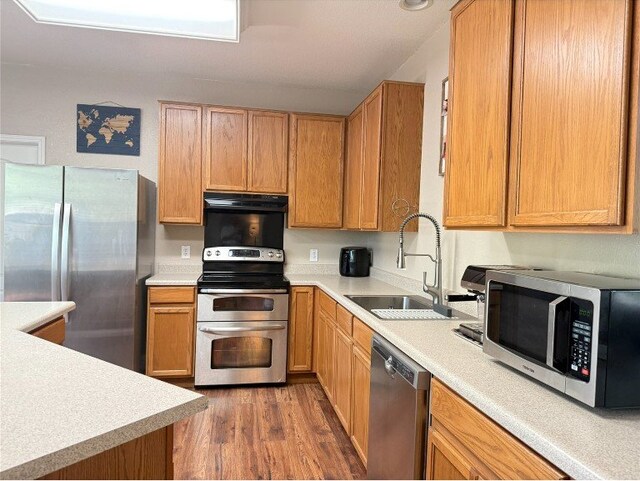 2201 Ezra Ct, Cedar Park, TX 78613 - kitchen featuring stainless steel appliances, under cabinet range hood, wood finished floors, and light countertops