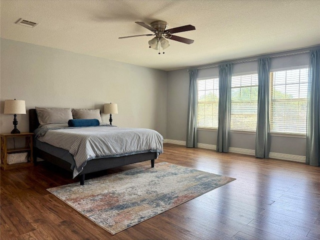 2201 Ezra Ct, Cedar Park, TX 78613 - bedroom featuring wood finished floors, baseboards, a ceiling fan, and a textured ceiling