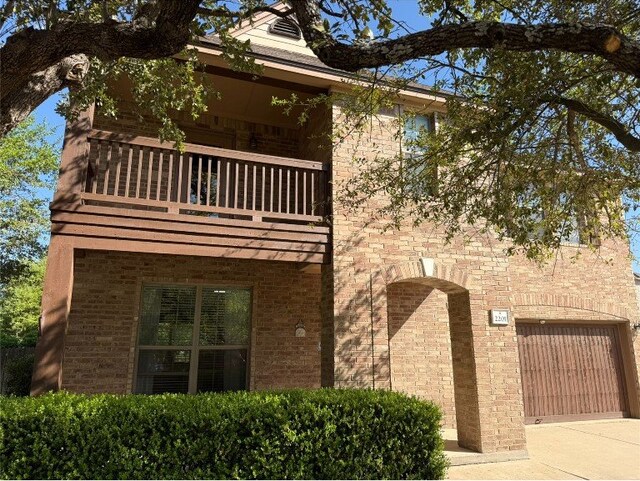 2201 Ezra Ct, Cedar Park, TX 78613 - view of front facade featuring a balcony, a garage, concrete driveway, and brick siding