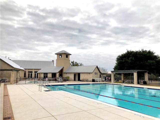 pool with a patio and fence
