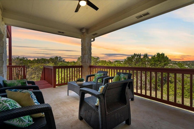 patio terrace at dusk with a ceiling fan and an outdoor hangout area