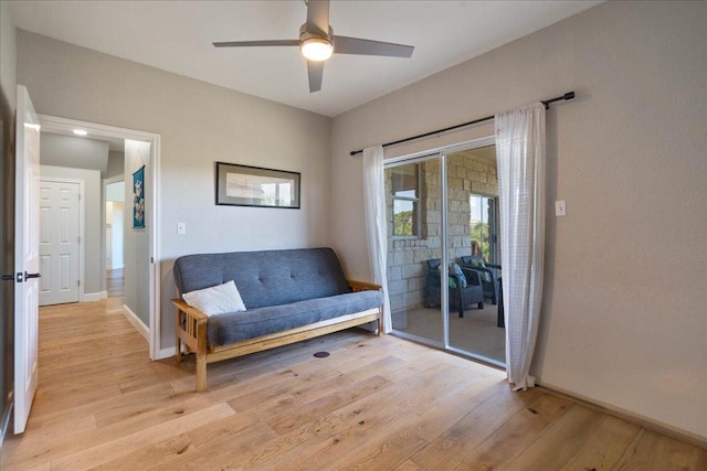 sitting room with light wood-type flooring, baseboards, and ceiling fan