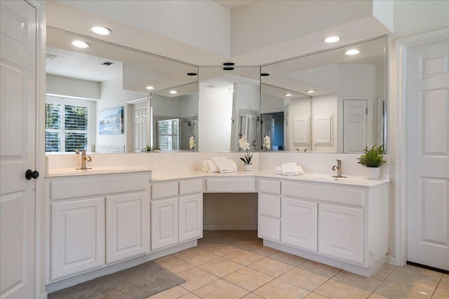19215 White Horse Cv, Spicewood, TX 78669 - full bathroom with double vanity, recessed lighting, an enclosed shower, and tile patterned floors